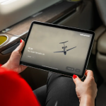 Passenger using the Pilatus PC-24 touchscreen inflight entertainment system.