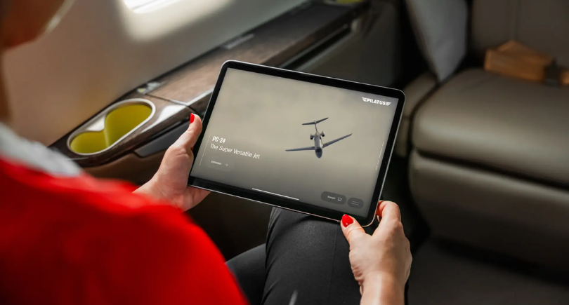 Passenger using the Pilatus PC-24 touchscreen inflight entertainment system.