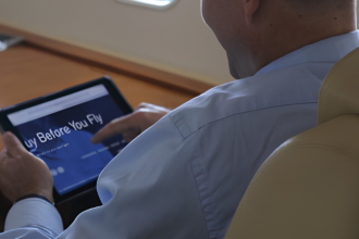 Business aircraft passenger using tablet during flight