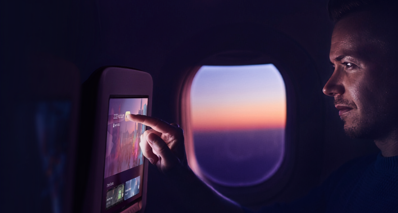 Passenger using Panasonic Avionics’ OLED in-flight entertainment screen.
